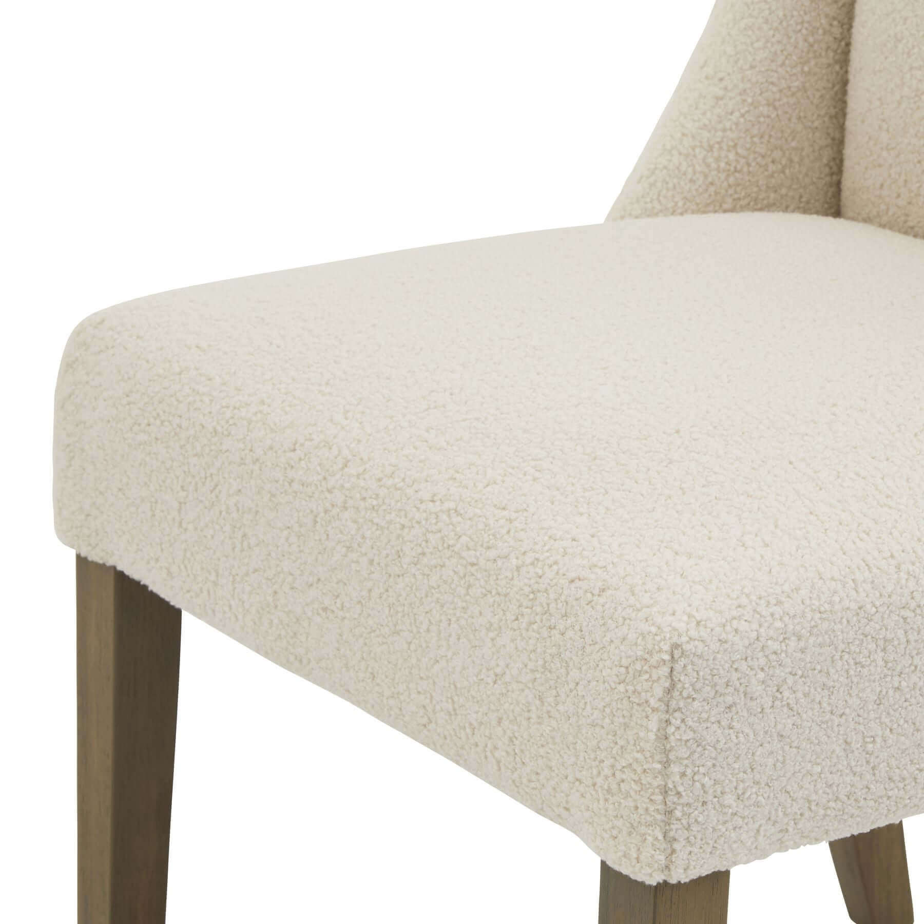 Compton Boucle Dining Chair | Description Introducing the Compton Boucle Dining Chair - a perfect blend of style and functionality. Crafted with a sturdy rubberwood frame, it offers strength and durability for everyday use. The cream boucle upholstery and