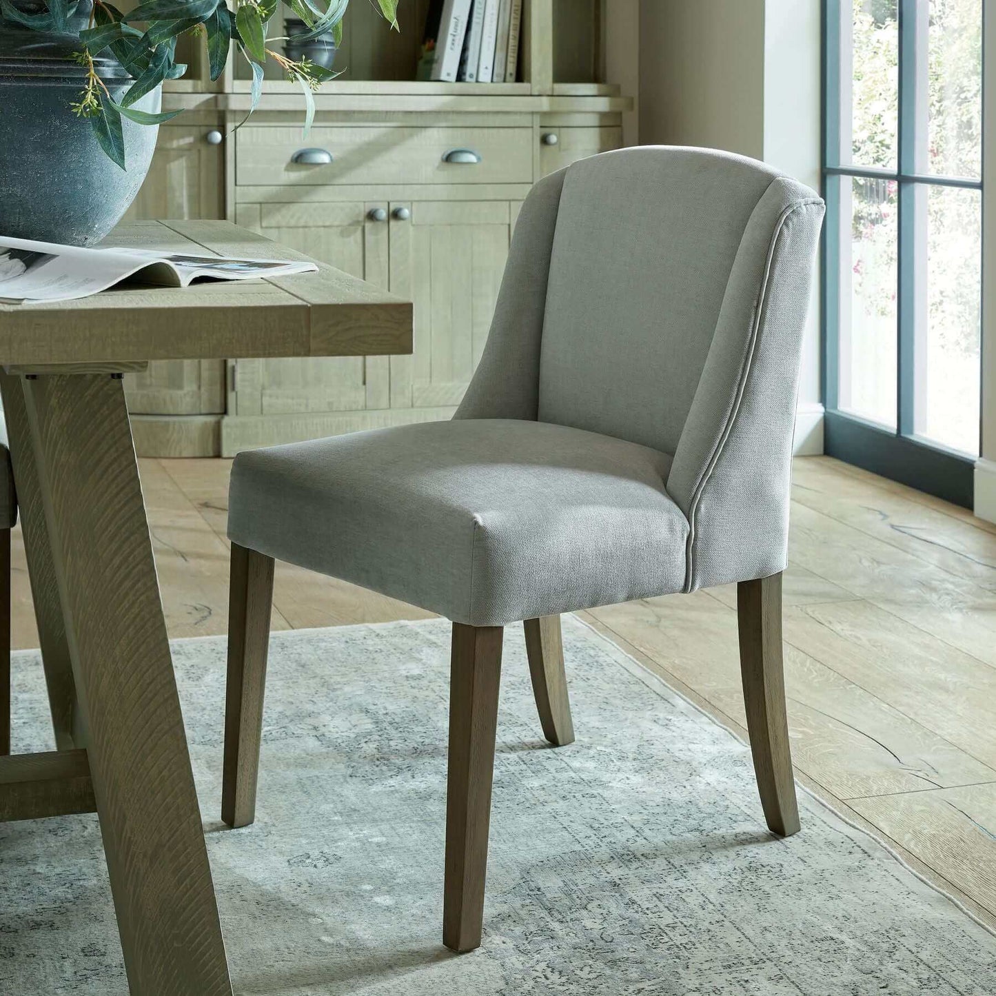 Compton Boucle Dining Chair | Description Introducing the Compton Boucle Dining Chair - a perfect blend of style and functionality. Crafted with a sturdy rubberwood frame, it offers strength and durability for everyday use. The cream boucle upholstery and